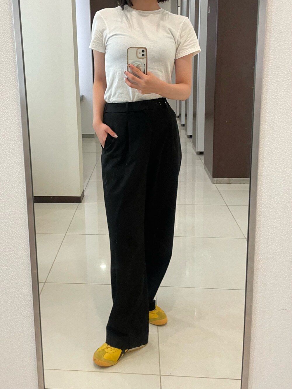 ホワイト系のTシャツ/カットソー、ブラック系のスラックス、イエロー系のスニーカーを着用したレディースの秋コーディネートの2枚目の写真