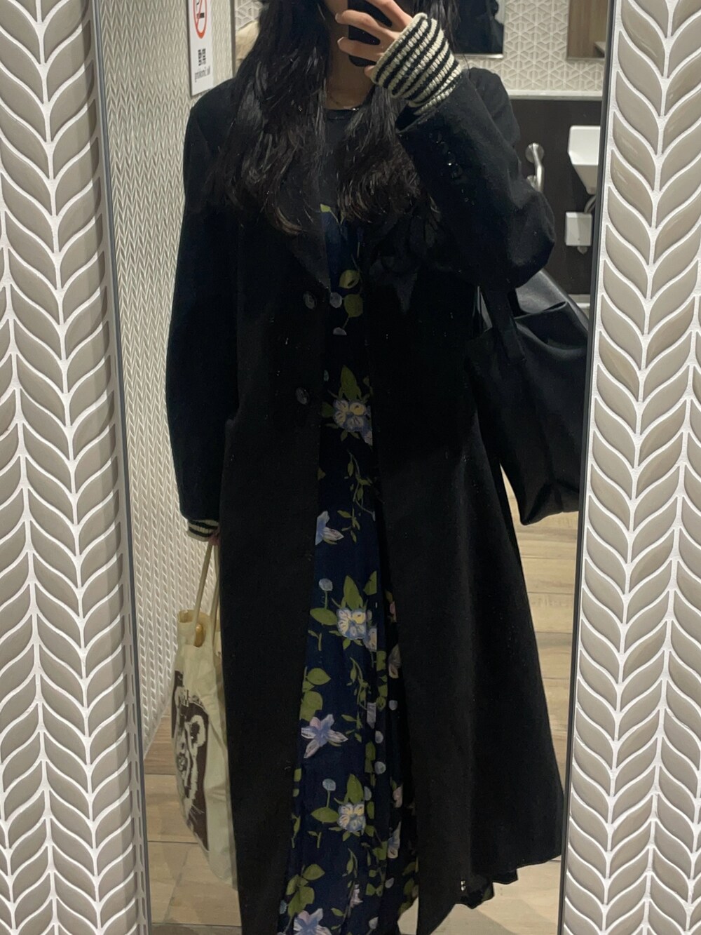 ブラック系のチェスターコート、ブルー系のワンピース/ドレス、ブラック系のバッグを着用したレディースの冬コーディネートの3枚目の写真