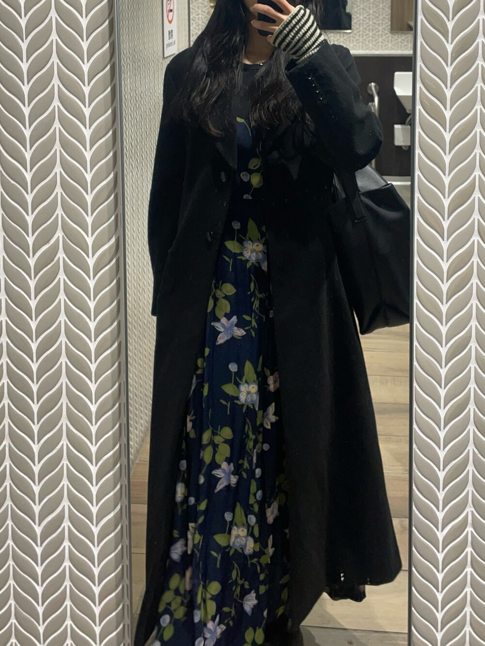 ブラック系のチェスターコート、ブルー系のワンピース/ドレス、ブラック系のバッグを着用したレディースの冬コーディネートの2枚目の写真