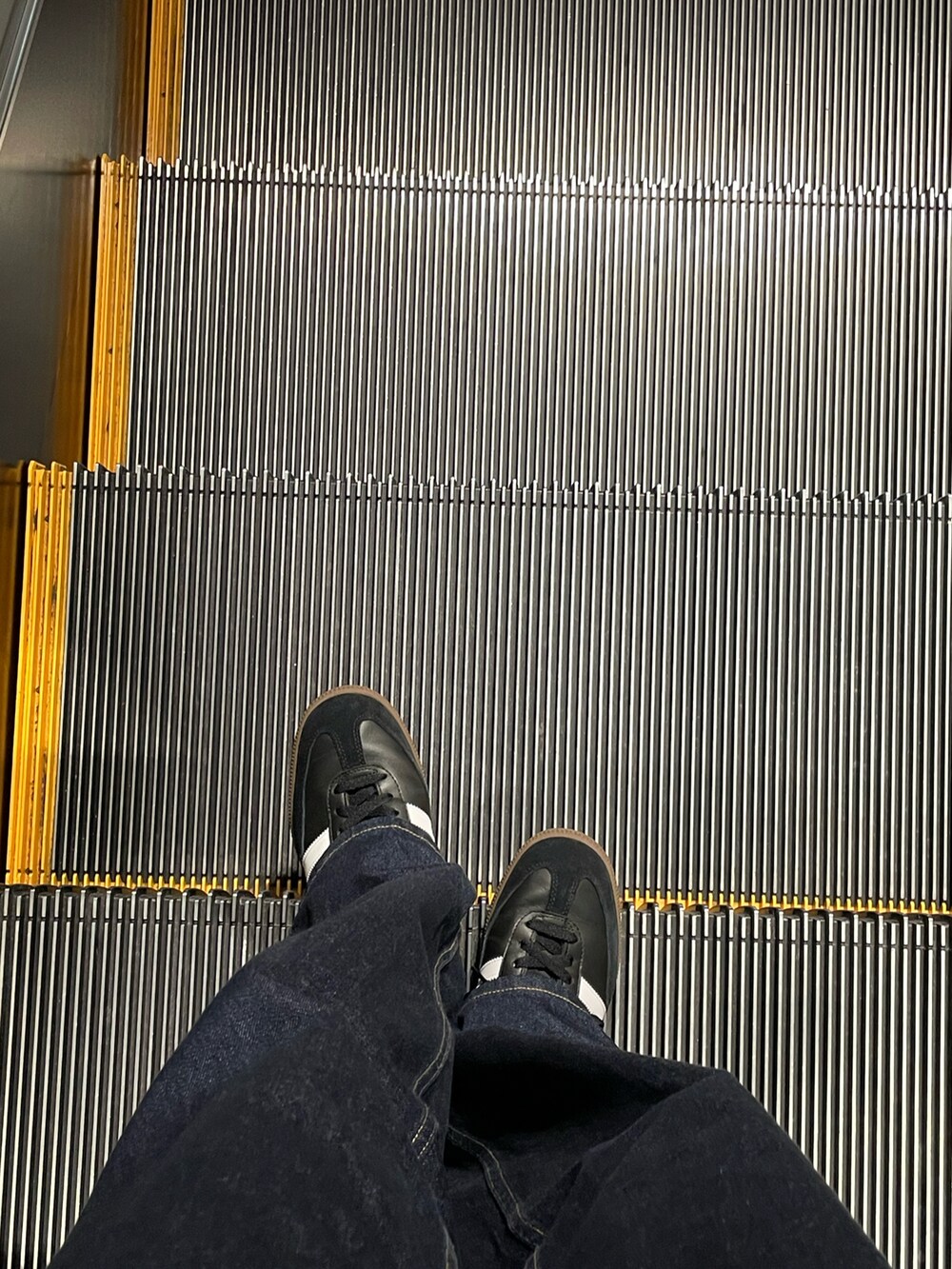 ホワイト系のTシャツ/カットソー、ブルー系のデニムパンツ、ブラック系のスニーカーを着用したレディースの秋コーディネートの4枚目の写真