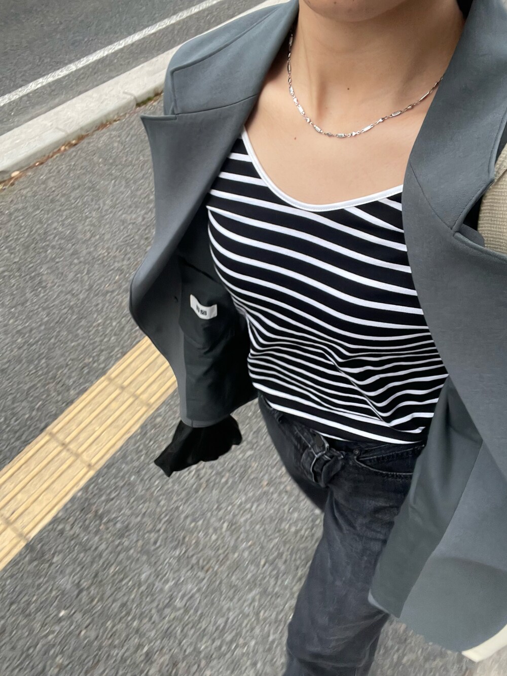 ブラック系のTシャツ/カットソー、グリーン系のテーラードジャケット、ブラック系のバッグを着用したレディースの春コーディネートの4枚目の写真