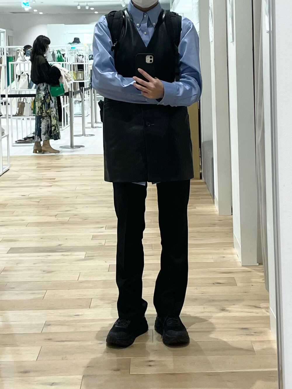 ブラック系のベスト、ブラック系のスラックス、ブラック系のスニーカーを着用したレディースの春コーディネートの3枚目の写真