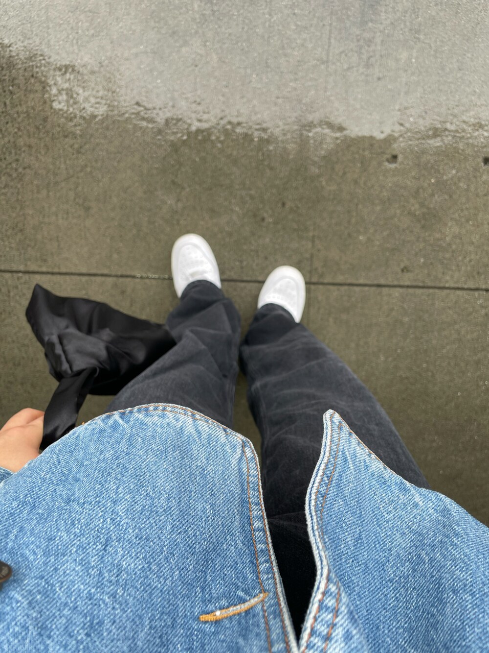 ブルー系のデニムジャケット、ブラック系のデニムパンツ、ホワイト系のスニーカーを着用したレディースの秋コーディネートの2枚目の写真