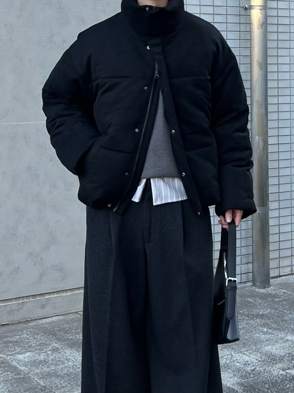 ブラック系のスニーカー、ブラック系のハンドバッグ、グレー系のシャツ/ブラウスを着用したメンズの冬コーディネートの2枚目の写真