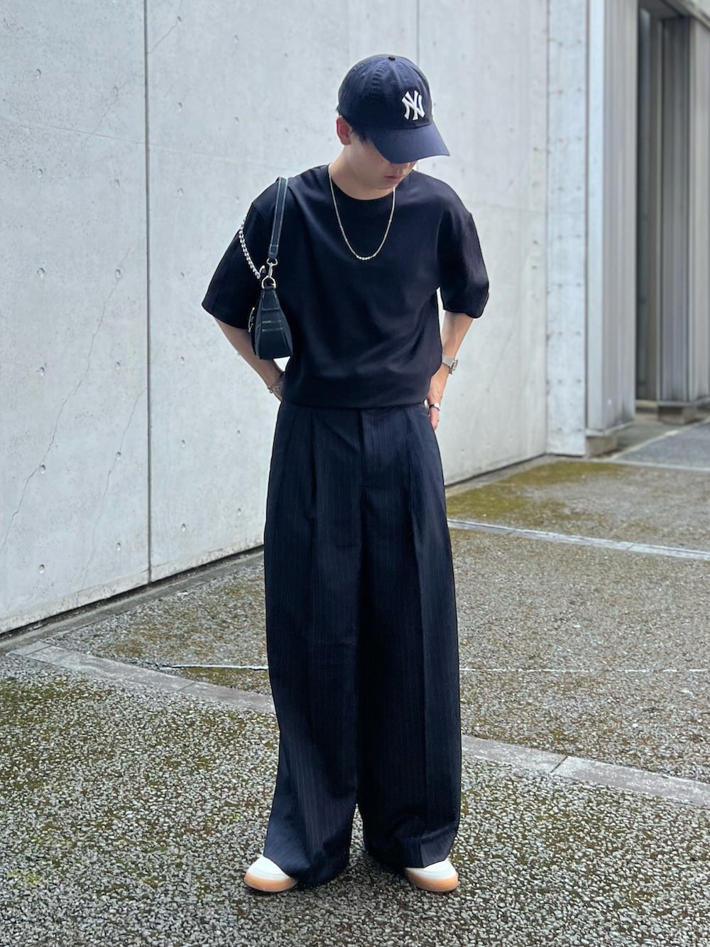 ブルー系のスラックス、ホワイト系のスニーカー、ブラック系のTシャツ/カットソーを着用したメンズの夏コーディネートの2枚目の写真