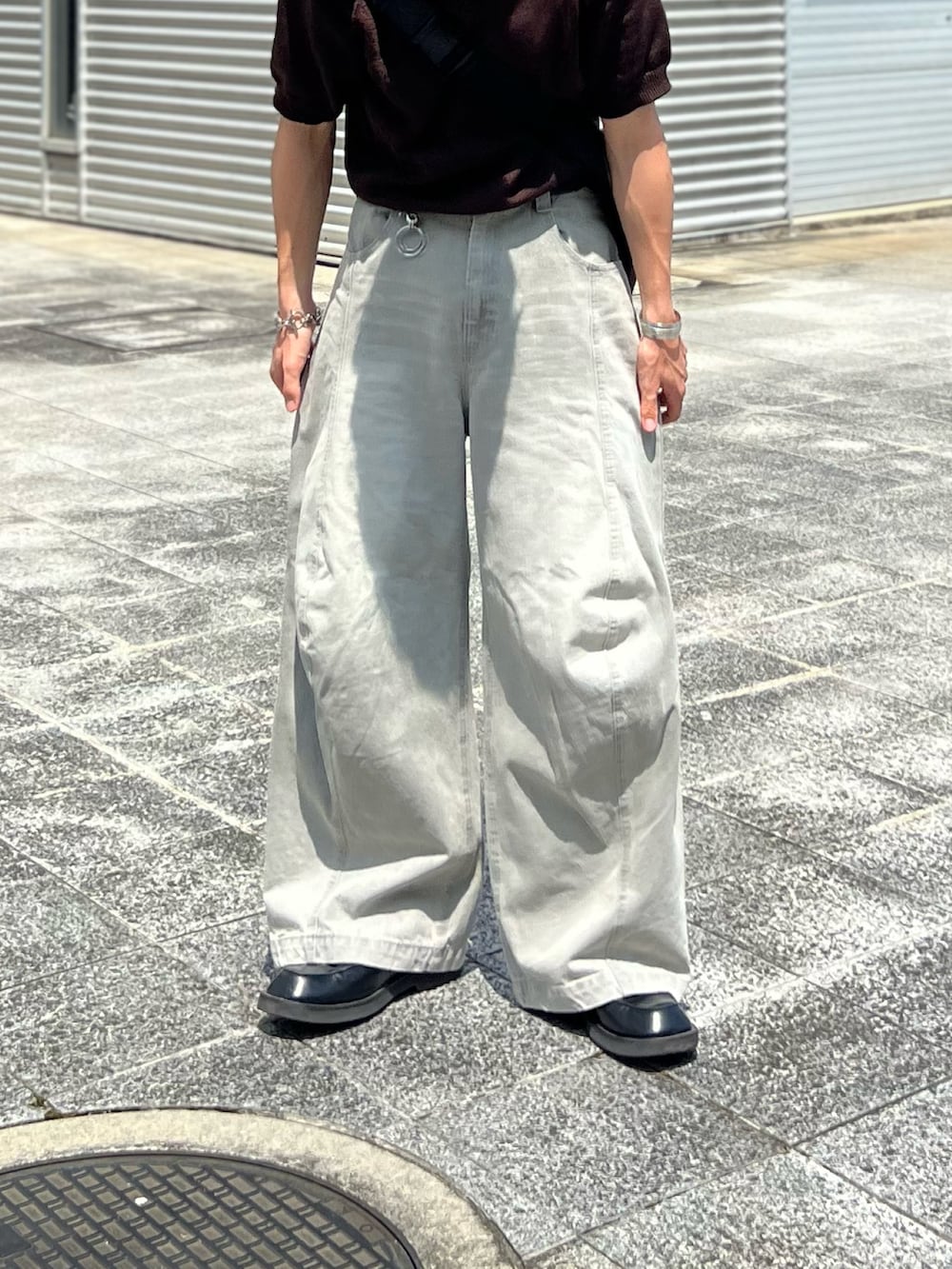 グレー系のデニムパンツ、ブラック系のローファー、ブラウン系のポロシャツを着用したメンズの夏コーディネートの2枚目の写真