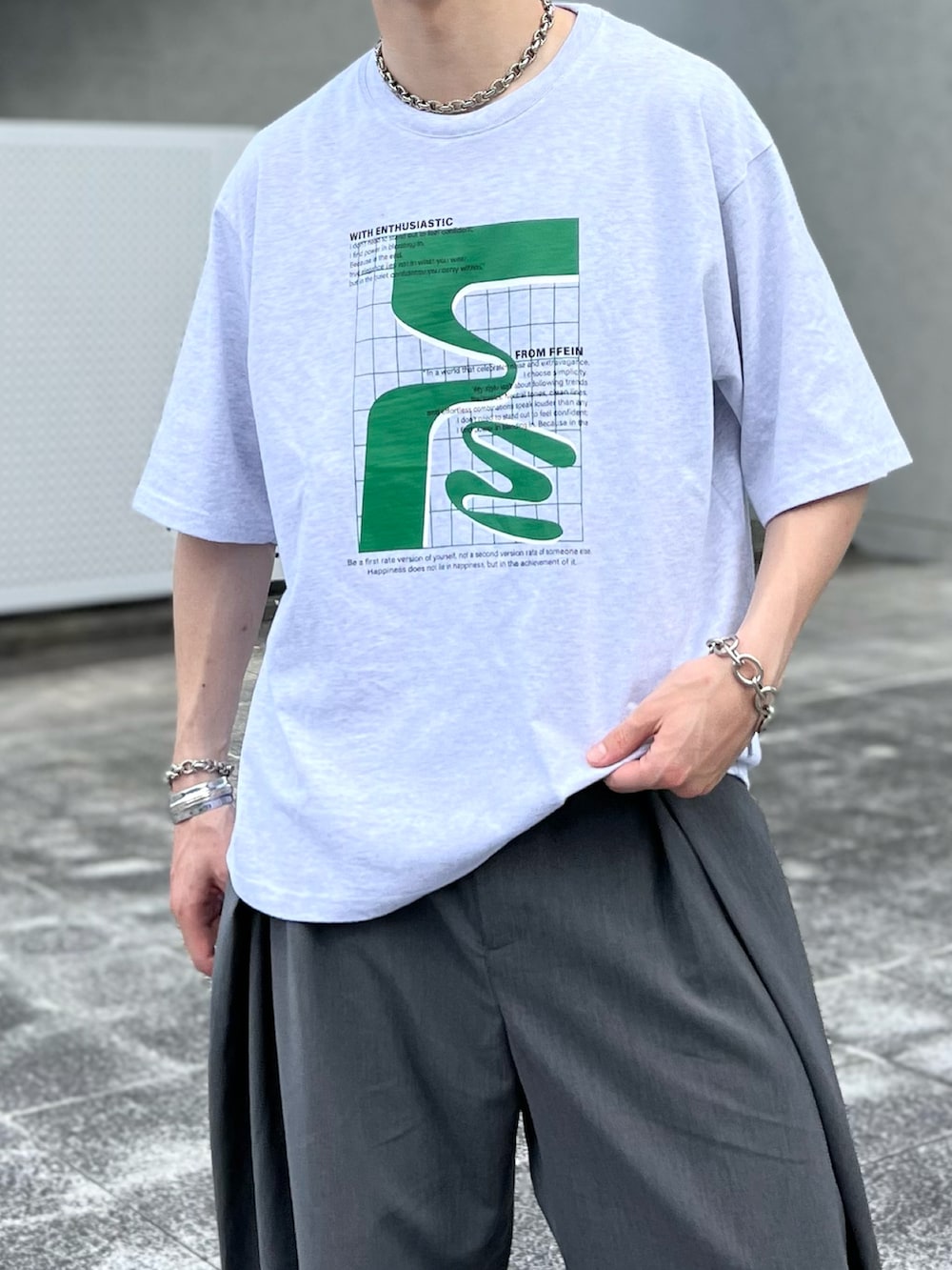 グレー系のスラックス、グレー系のTシャツ/カットソー、ブラウン系のローファーを着用したメンズの夏コーディネートの2枚目の写真