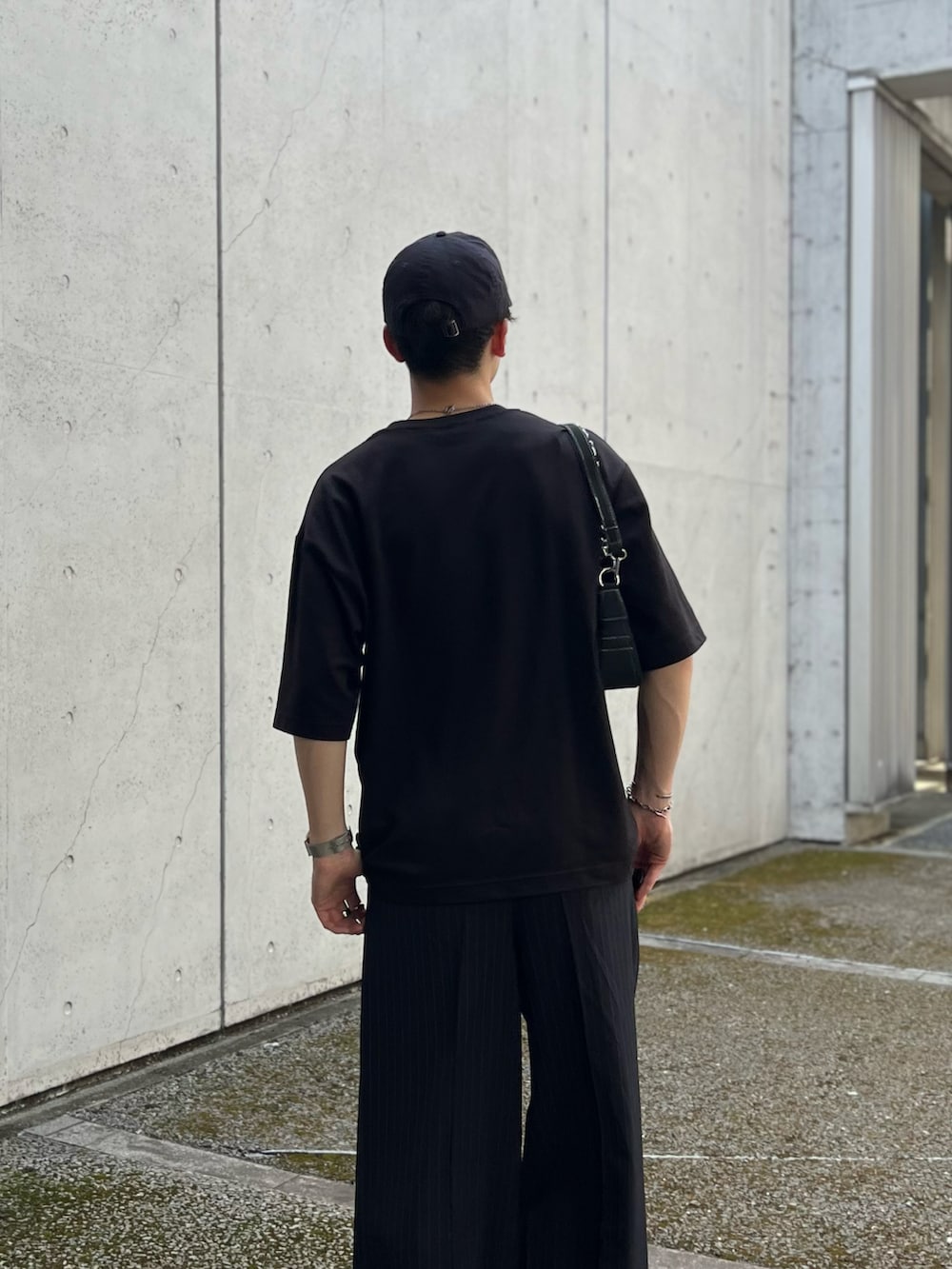 ブルー系のスラックス、ホワイト系のスニーカー、ブラック系のTシャツ/カットソーを着用したメンズの夏コーディネートの3枚目の写真