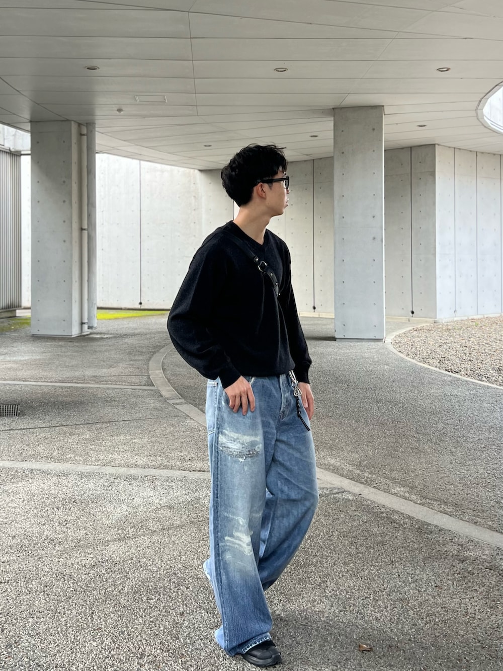 ブラック系のスニーカー、グレー系のニット/セーター、ブルー系のデニムパンツを着用したメンズの秋コーディネートの2枚目の写真