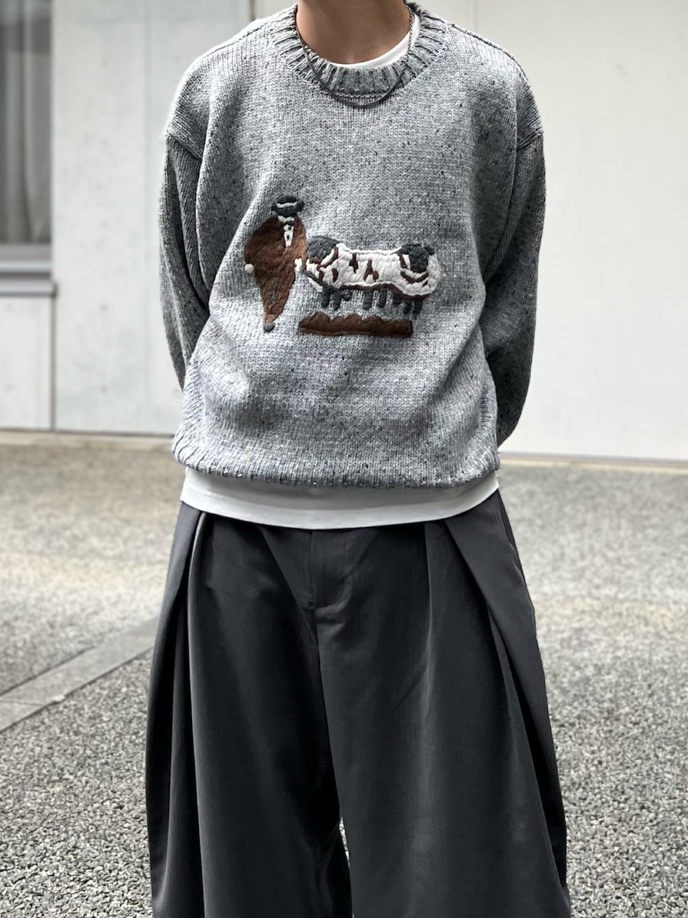 ブラック系のハンドバッグ、グレー系のニット/セーター、グレー系のスラックスを着用したメンズの秋コーディネートの2枚目の写真