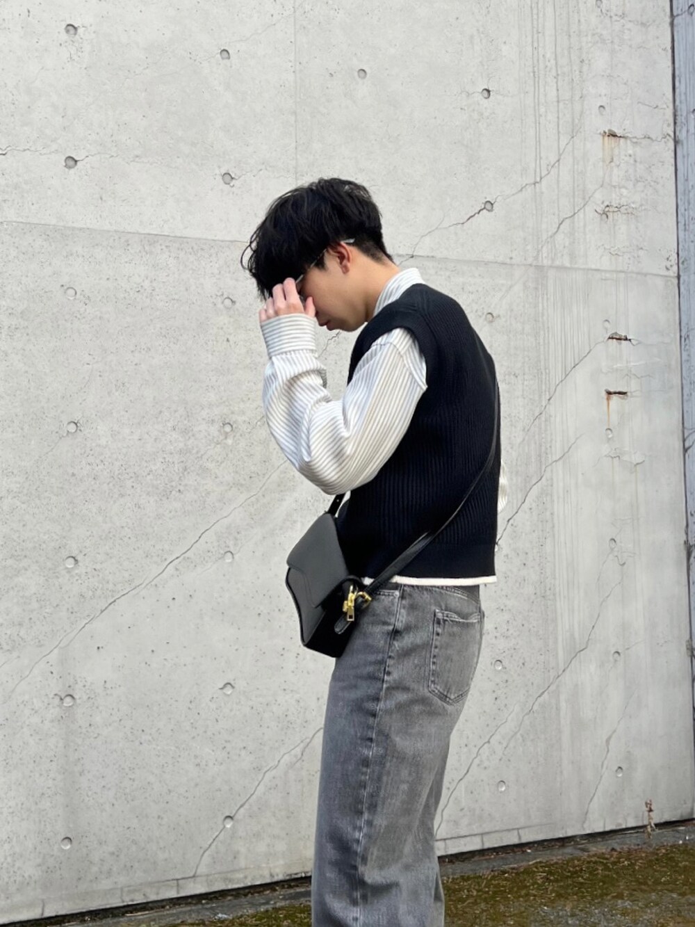 グレー系のスニーカー、グレー系のデニムパンツ、ホワイト系のシャツ/ブラウスを着用したメンズの春コーディネートの2枚目の写真