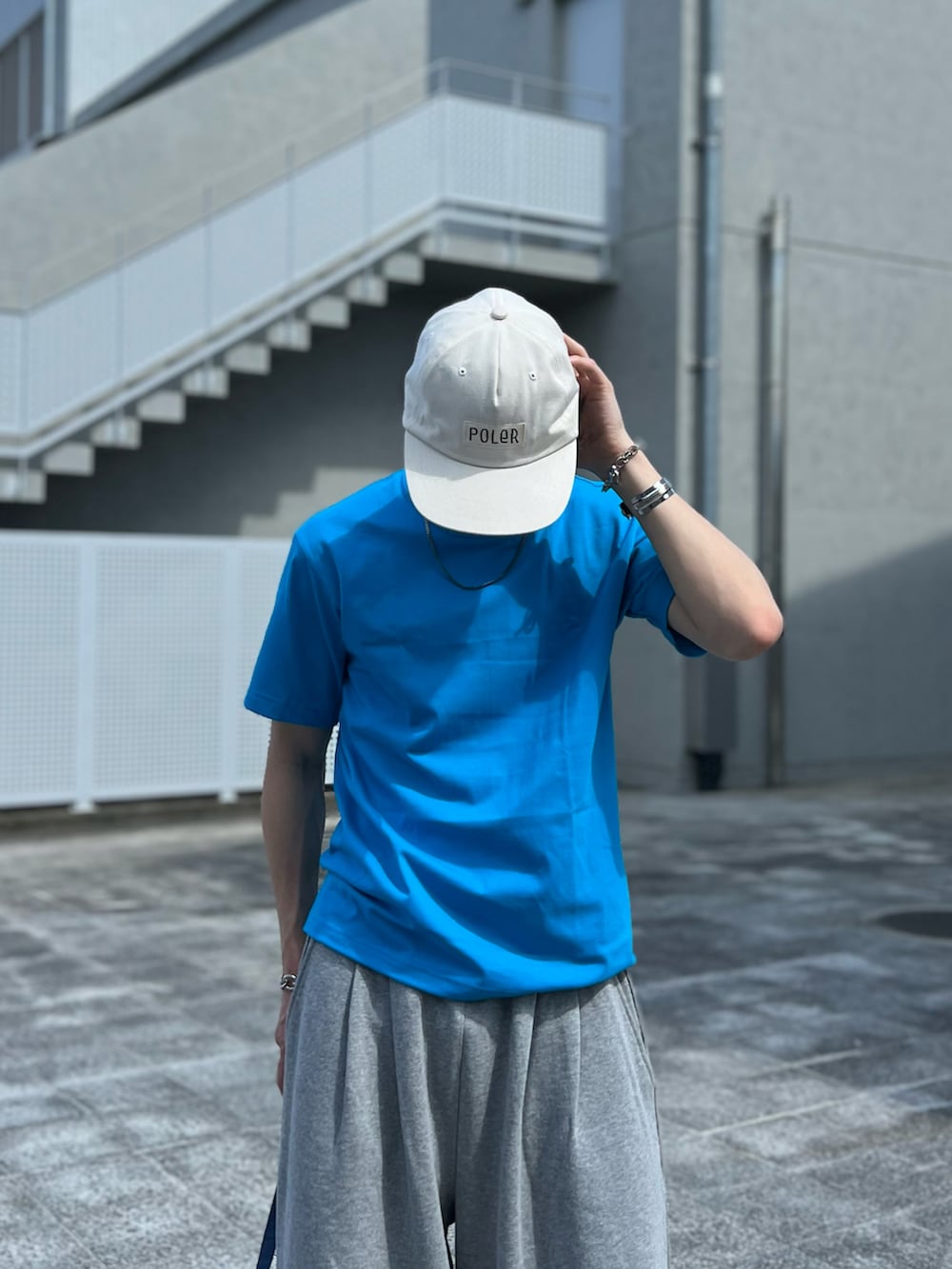 ブルー系のトートバッグ、グレー系のスウェットパンツ、ホワイト系のスニーカーを着用したメンズの夏コーディネートの3枚目の写真