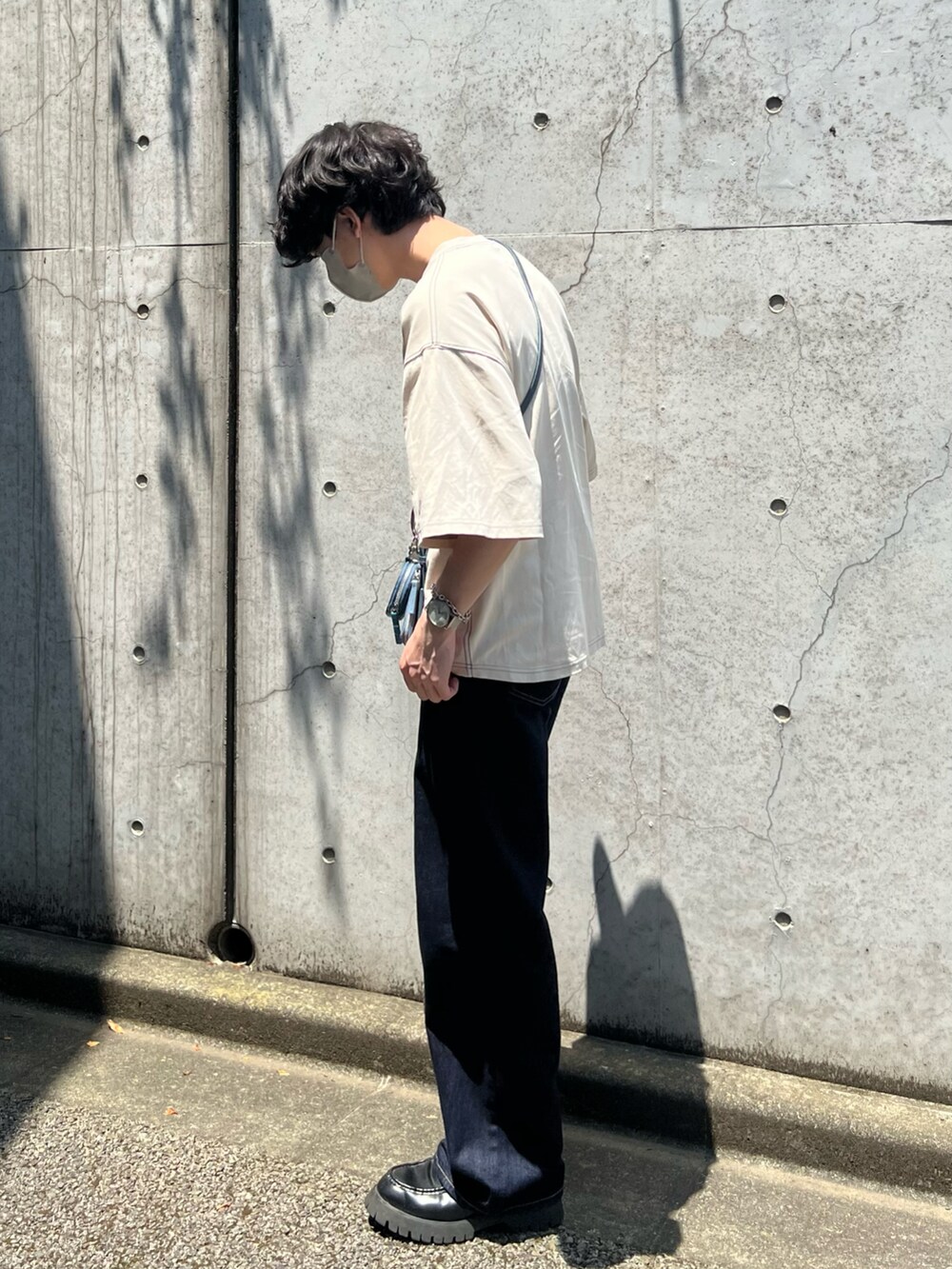 ブルー系のデニムパンツ、ブラック系のローファー、ブルー系のショルダーバッグを着用したメンズの夏コーディネートの2枚目の写真