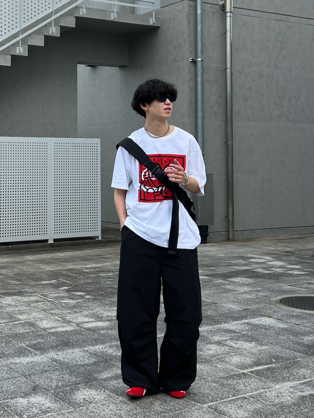 ブラック系のショルダーバッグ、ホワイト系のTシャツ/カットソー、ブラック系のその他パンツを着用したメンズの春コーディネートの2枚目の写真