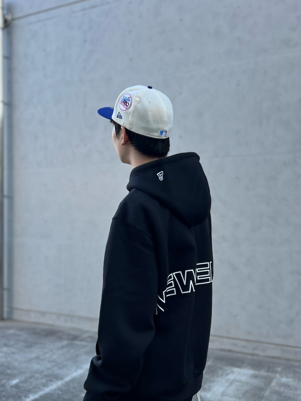 グレー系のショルダーバッグ、ブラック系のパーカー、ブラック系のスラックスを着用したメンズの秋コーディネートの3枚目の写真