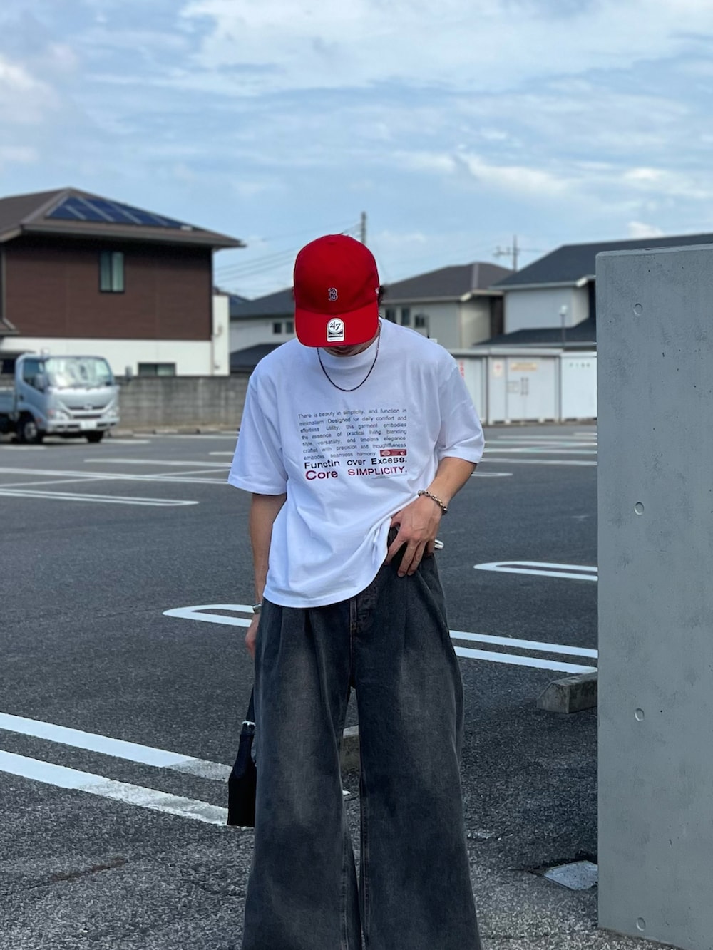 ホワイト系のTシャツ/カットソー、ブラック系のデニムパンツ、ブラック系のハンドバッグを着用したメンズの夏コーディネートの3枚目の写真