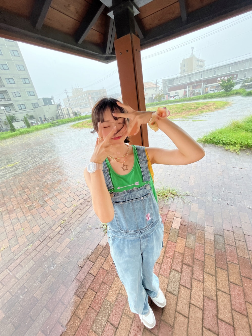 ブルー系のサロペット/オーバーオール、ホワイト系のスニーカー、イエロー系のタンクトップを着用したレディースの夏コーディネートの2枚目の写真