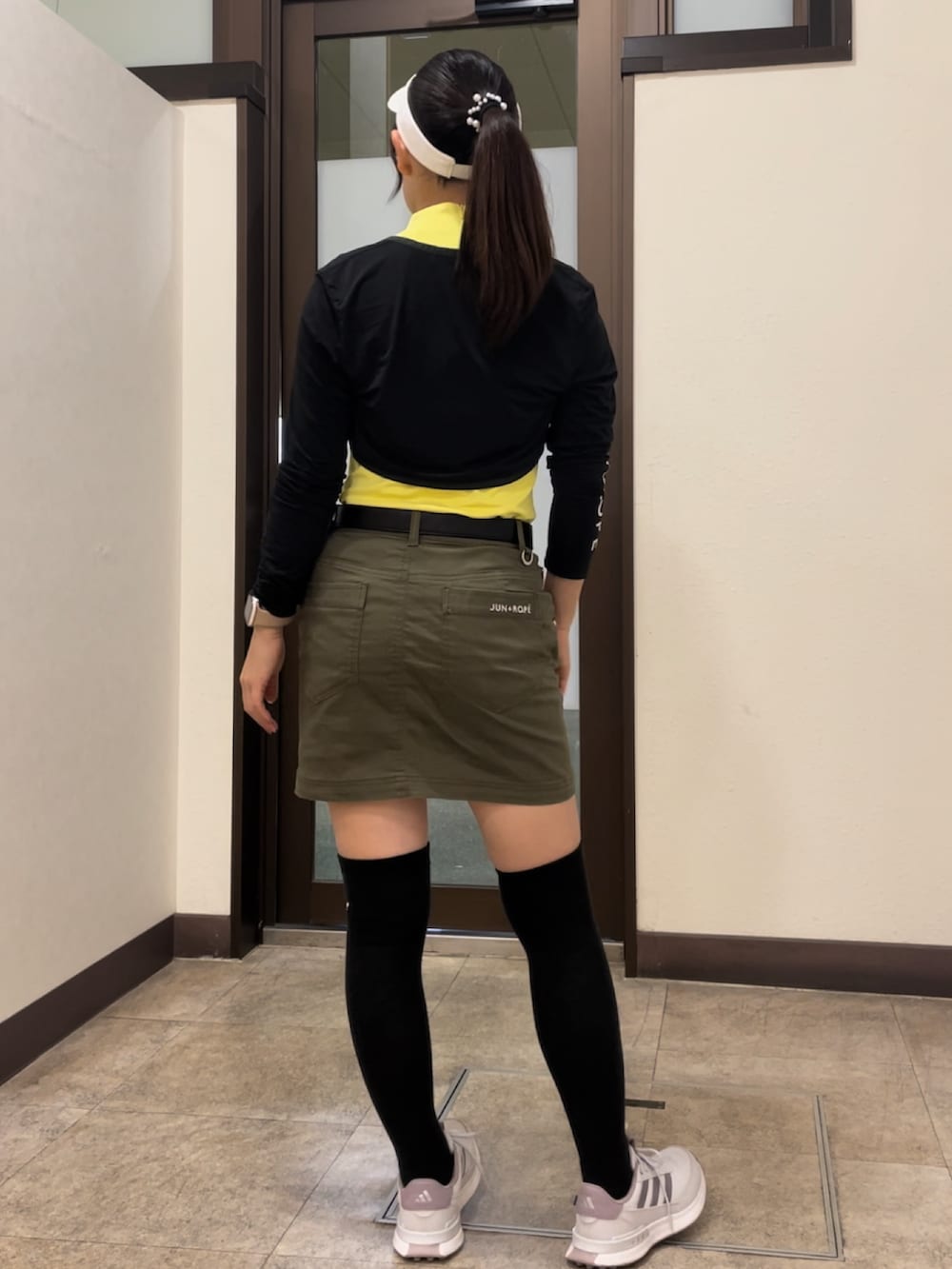 グリーン系のスカート、イエロー系のTシャツ/カットソー、ホワイト系のスニーカーを着用したレディースの秋コーディネートの2枚目の写真