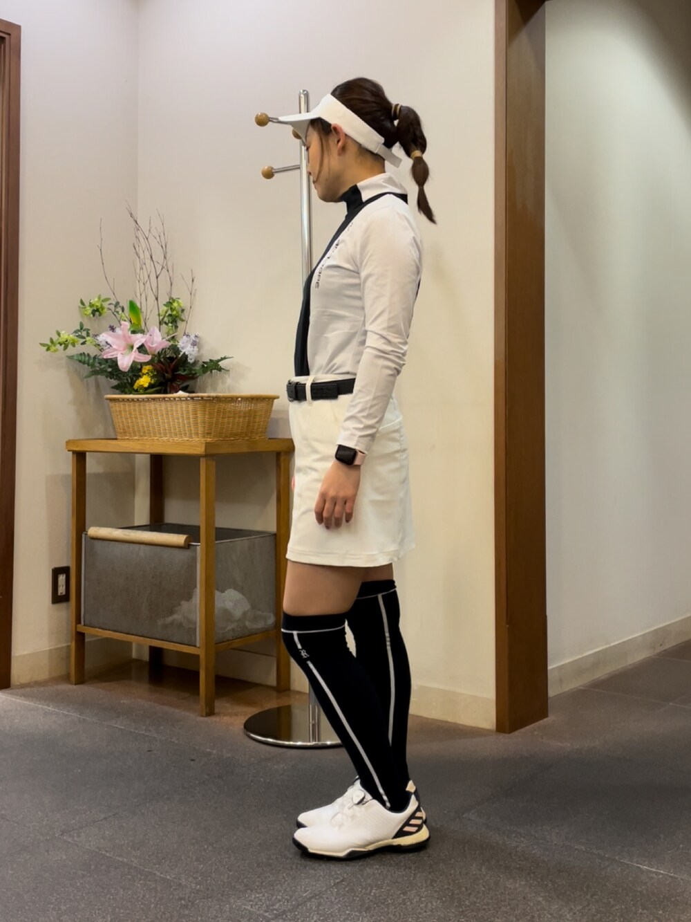 ホワイト系のスカート、ブラック系のTシャツ/カットソー、ホワイト系のスニーカーを着用したレディースの秋コーディネートの3枚目の写真