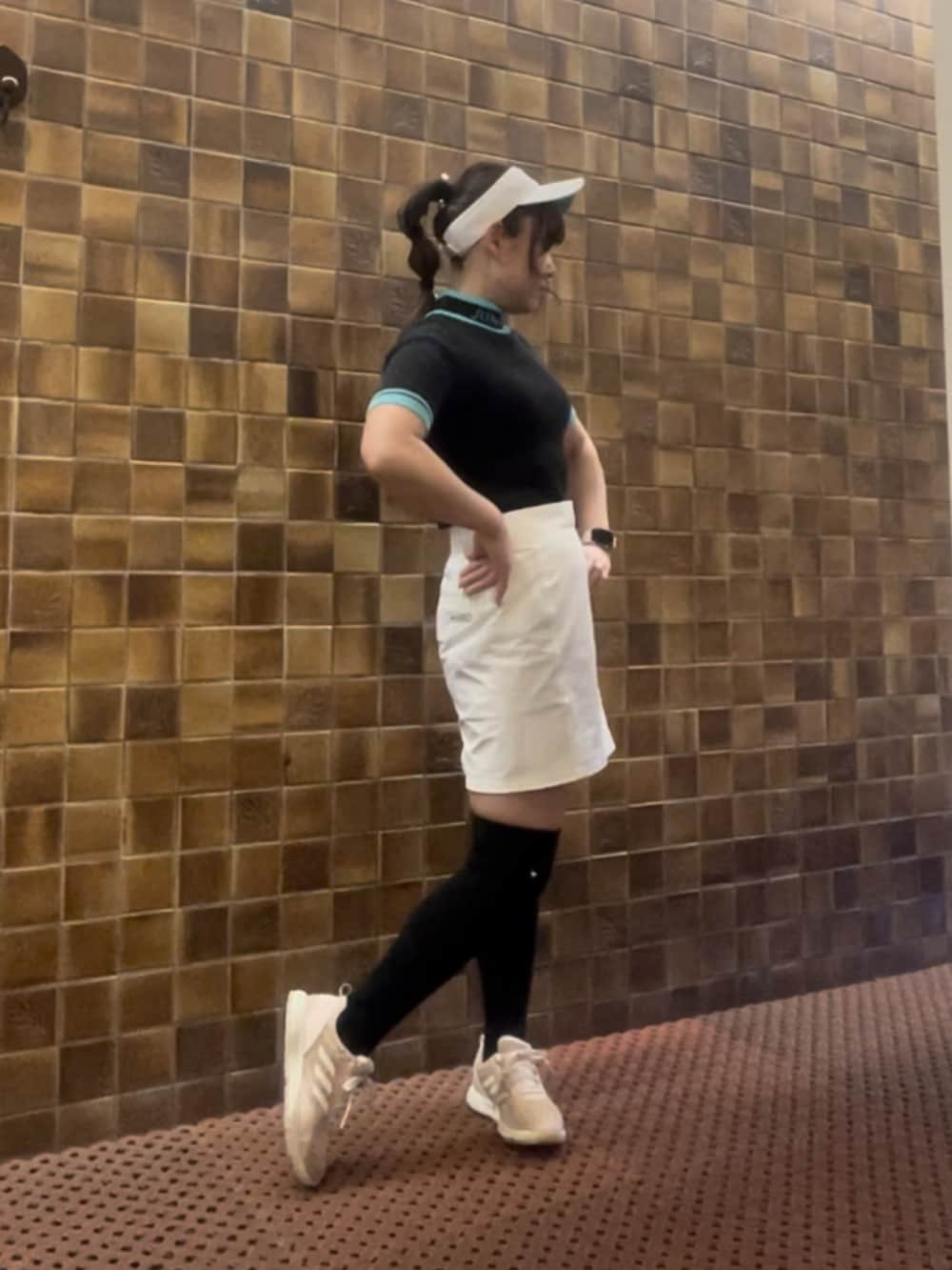 ブラック系のニット/セーター、ホワイト系のスカート、ピンク系のスニーカーを着用したレディースの春コーディネートの2枚目の写真