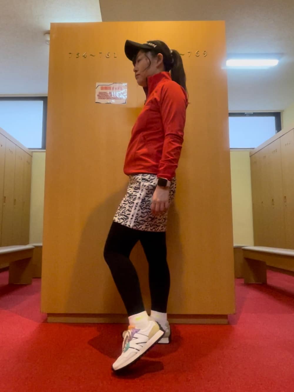 グレー系のスカート、ホワイト系のトップス、ホワイト系のスニーカーを着用したレディースの春コーディネートの3枚目の写真