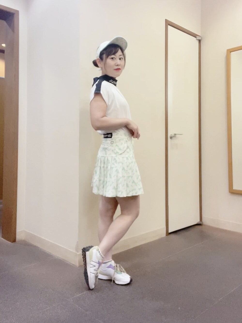 ホワイト系のスカート、ホワイト系のTシャツ/カットソー、ホワイト系のスニーカーを着用したレディースの夏コーディネートの2枚目の写真