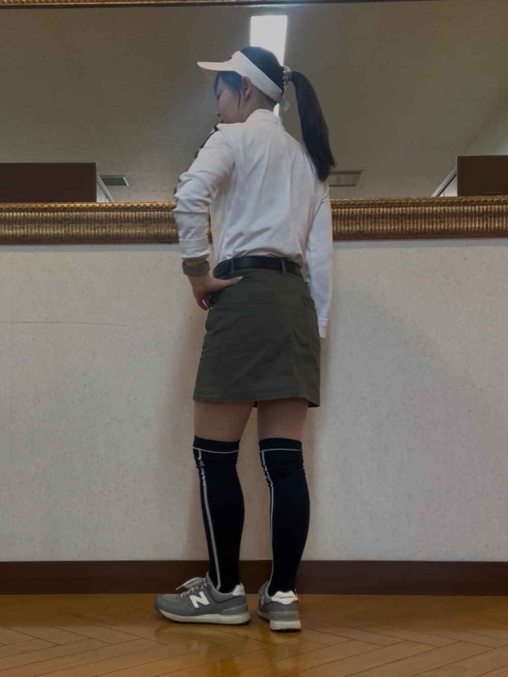 グリーン系のスカート、ホワイト系のTシャツ/カットソー、グレー系のスニーカーを着用したレディースの春コーディネートの2枚目の写真