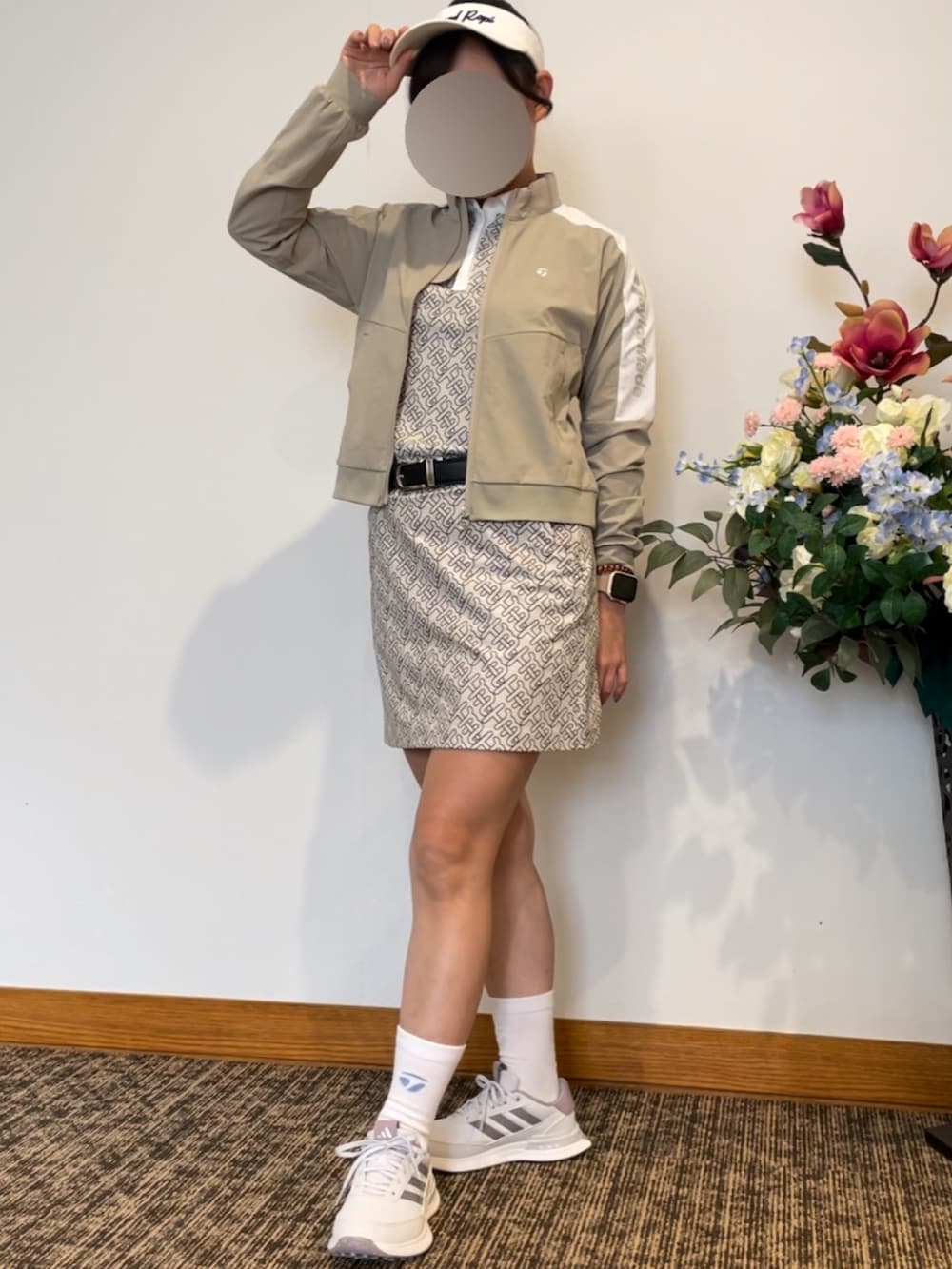 ベージュ系のポロシャツ、ベージュ系のスカート、ホワイト系のスニーカーを着用したレディースの秋コーディネートの3枚目の写真