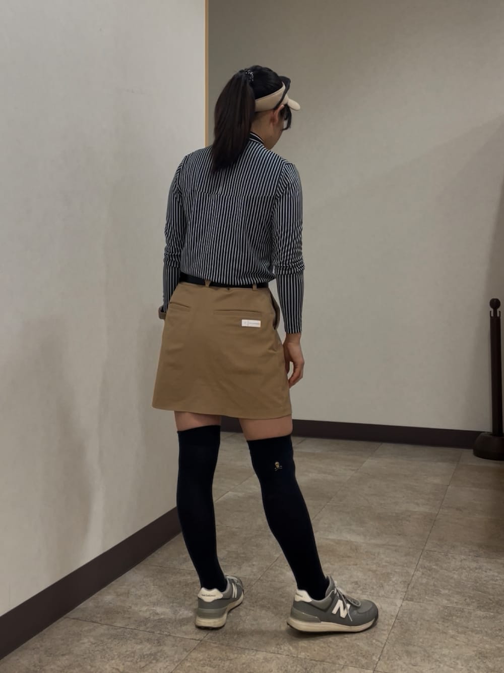 ベージュ系のスカート、ブルー系のTシャツ/カットソー、ベージュ系のサンバイザーを着用したレディースの春コーディネートの3枚目の写真