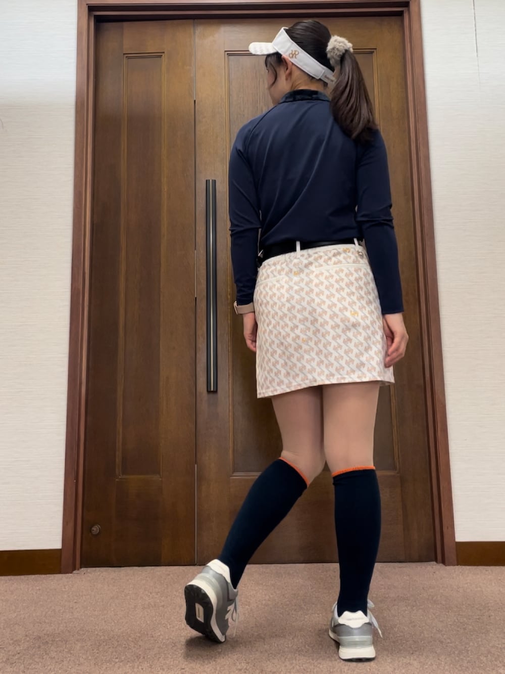 ホワイト系のスカート、ブルー系のTシャツ/カットソー、グレー系のスニーカーを着用したレディースの秋コーディネートの2枚目の写真