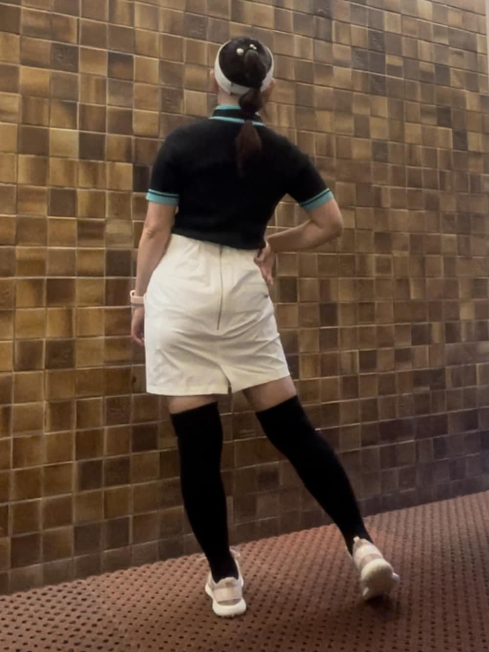 ブラック系のニット/セーター、ホワイト系のスカート、ピンク系のスニーカーを着用したレディースの春コーディネートの3枚目の写真