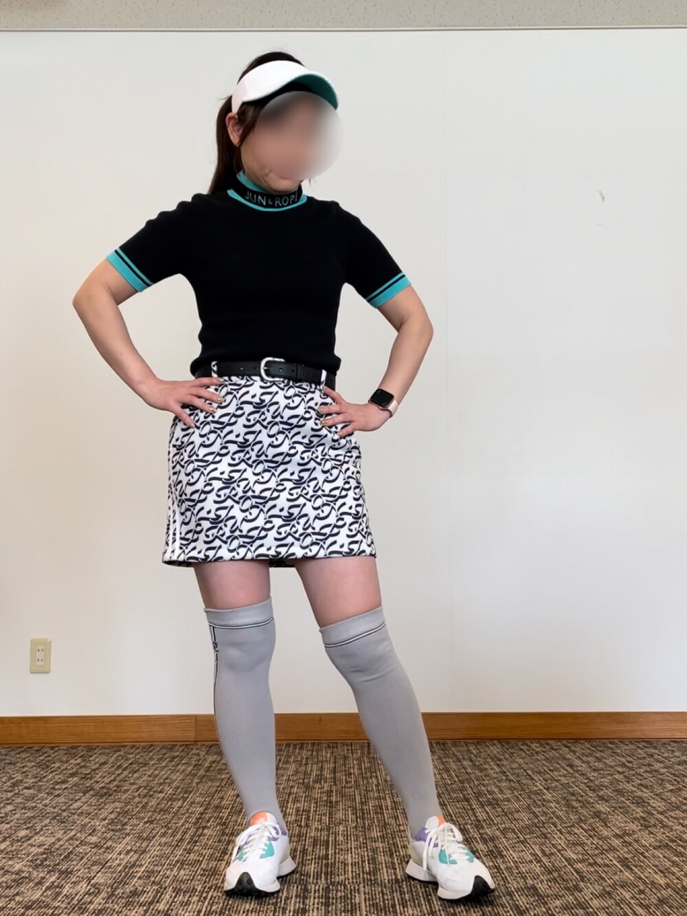 ホワイト系のスニーカー、グレー系のスカート、ブラック系のニット/セーターを着用したレディースの春コーディネートの3枚目の写真