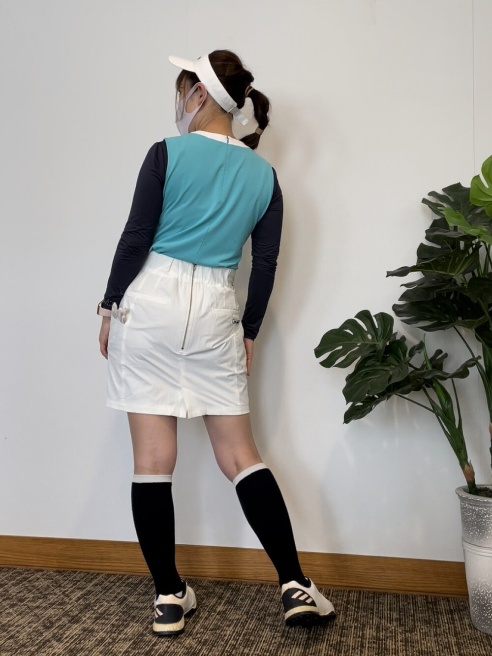 ホワイト系のスカート、グリーン系のTシャツ/カットソー、ホワイト系のスニーカーを着用したレディースの秋コーディネートの2枚目の写真