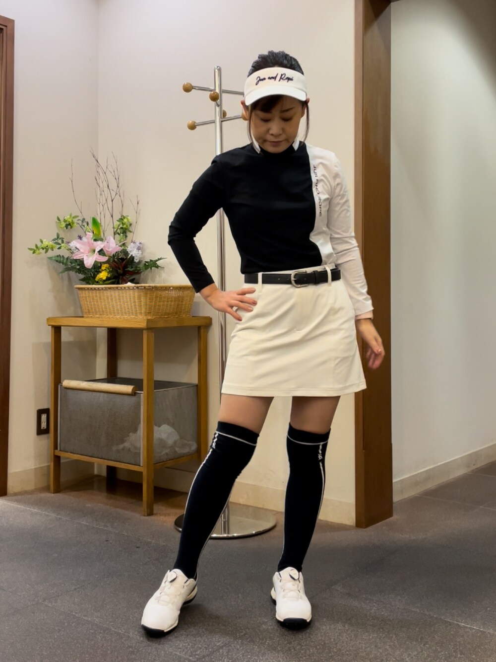 ホワイト系のスカート、ブラック系のTシャツ/カットソー、ホワイト系のスニーカーを着用したレディースの秋コーディネートの4枚目の写真