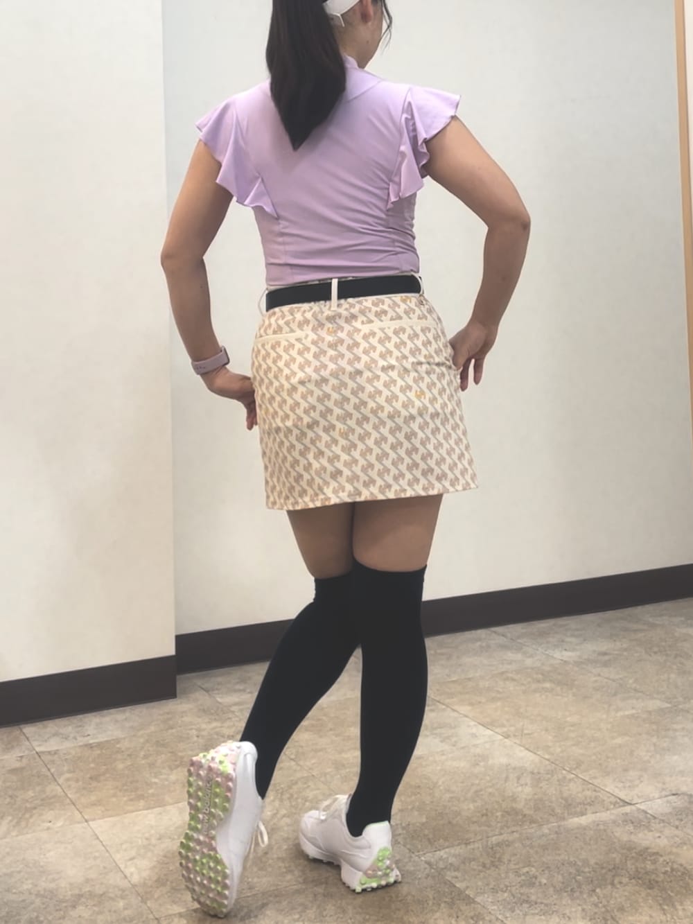 パープル系のトップス、ホワイト系のスカート、ホワイト系のスニーカーを着用したレディースの夏コーディネートの3枚目の写真