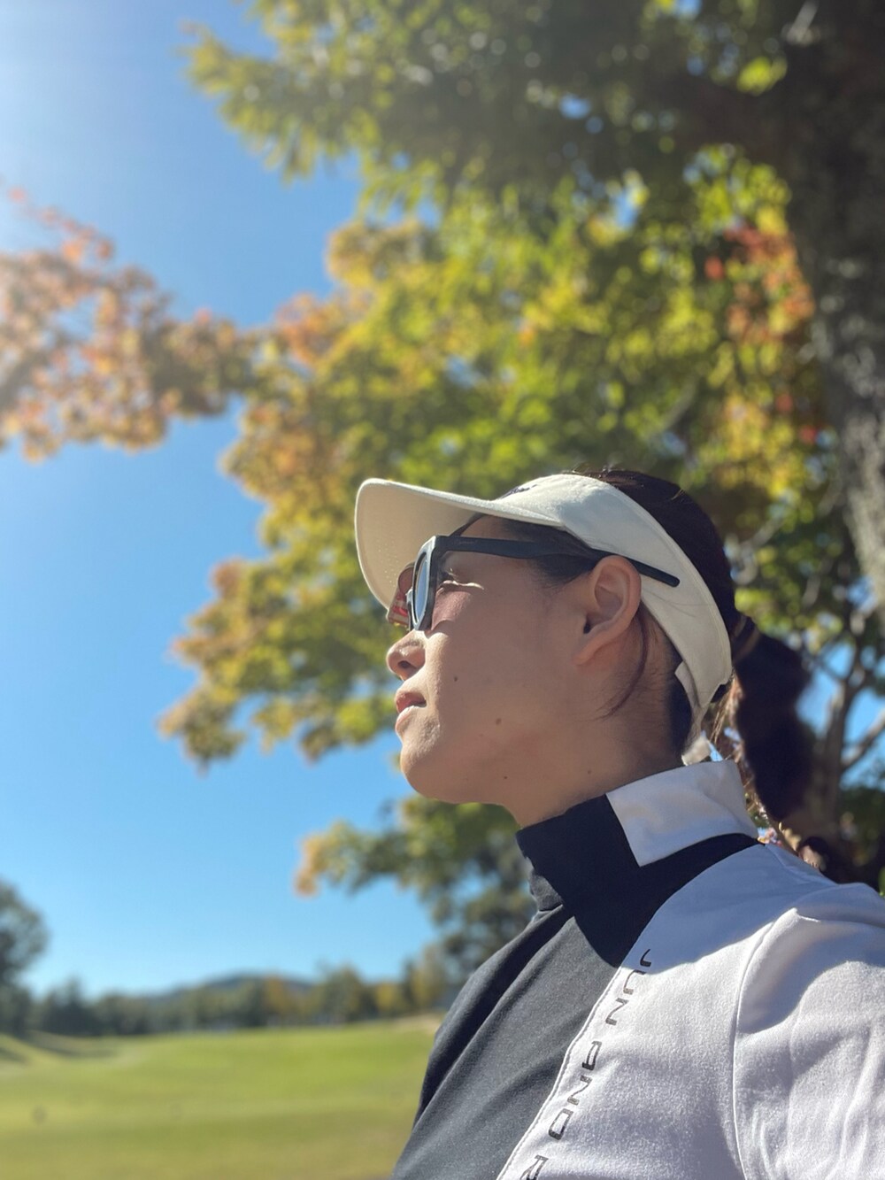 ホワイト系のスカート、ブラック系のTシャツ/カットソー、ホワイト系のスニーカーを着用したレディースの秋コーディネートの5枚目の写真