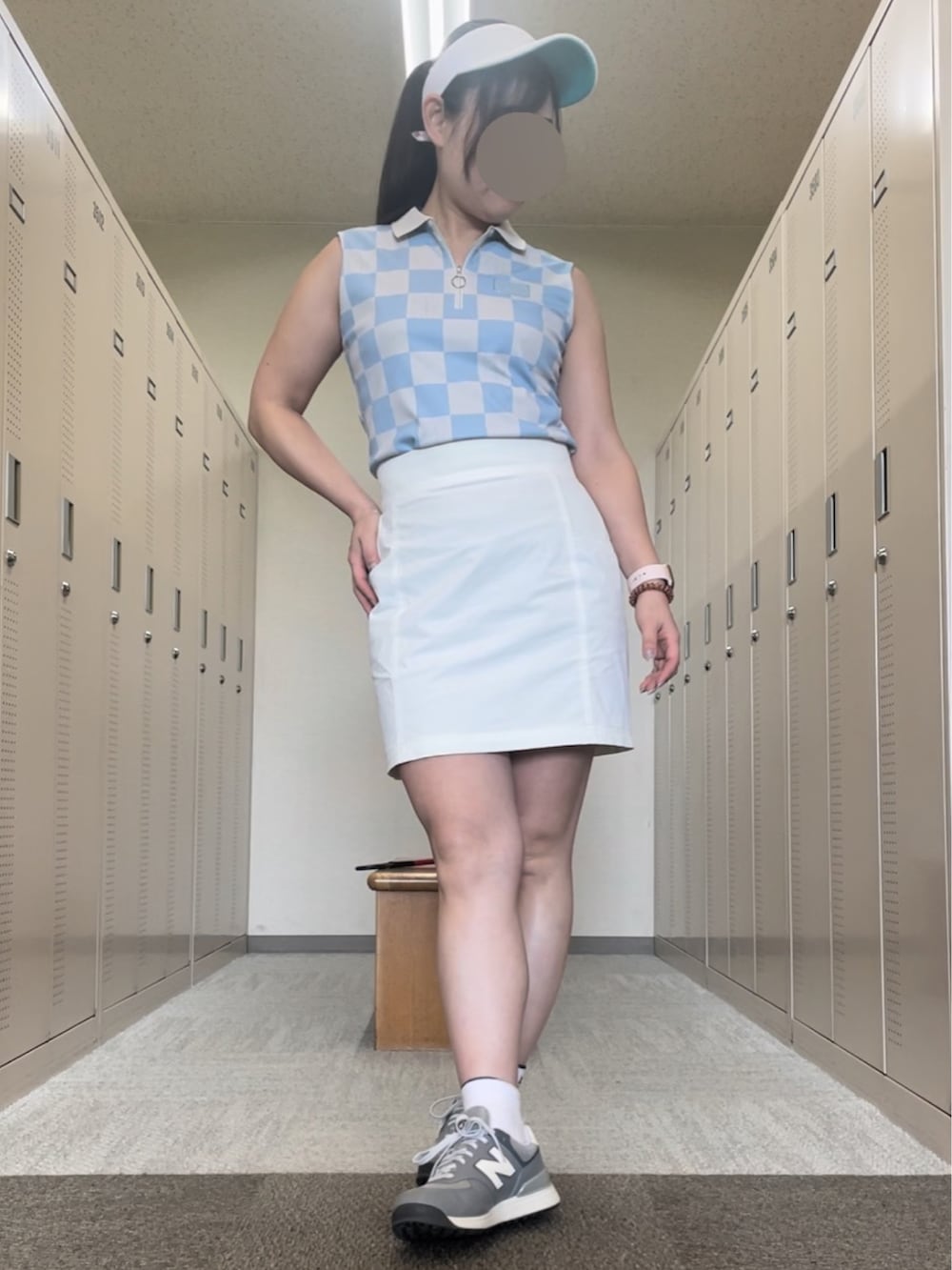 ホワイト系のスカート、グレー系のスニーカー、ブルー系のポロシャツを着用したレディースの夏コーディネートの3枚目の写真