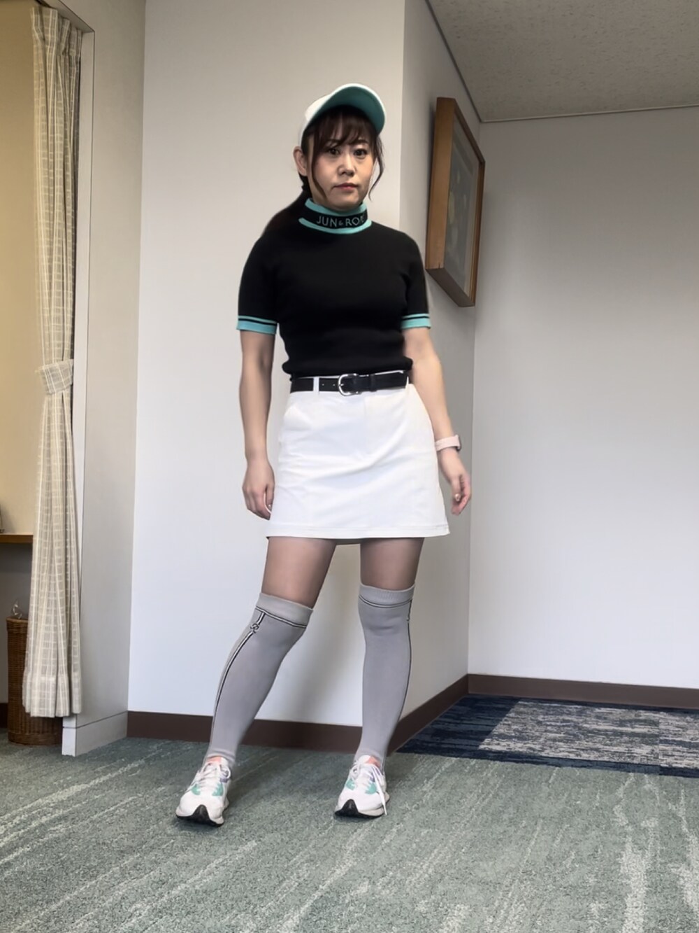 ブラック系のニット/セーター、ホワイト系のスカート、ホワイト系のスニーカーを着用したレディースの春コーディネートの3枚目の写真