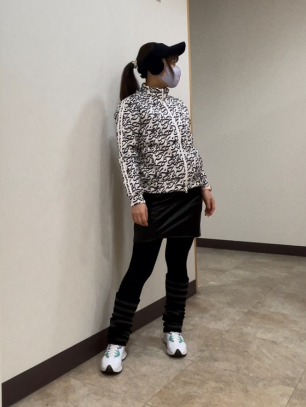 ブラック系のスカート、ホワイト系のスニーカー、グレー系のブルゾンを着用したレディースの冬コーディネートの2枚目の写真