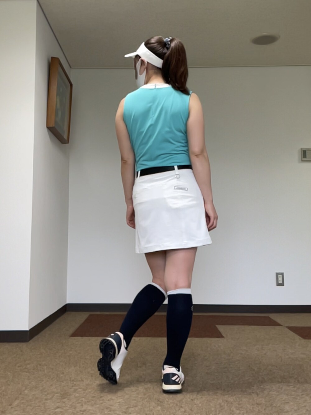 グリーン系のTシャツ/カットソー、ホワイト系のスカート、ホワイト系のスニーカーを着用したレディースの夏コーディネートの2枚目の写真