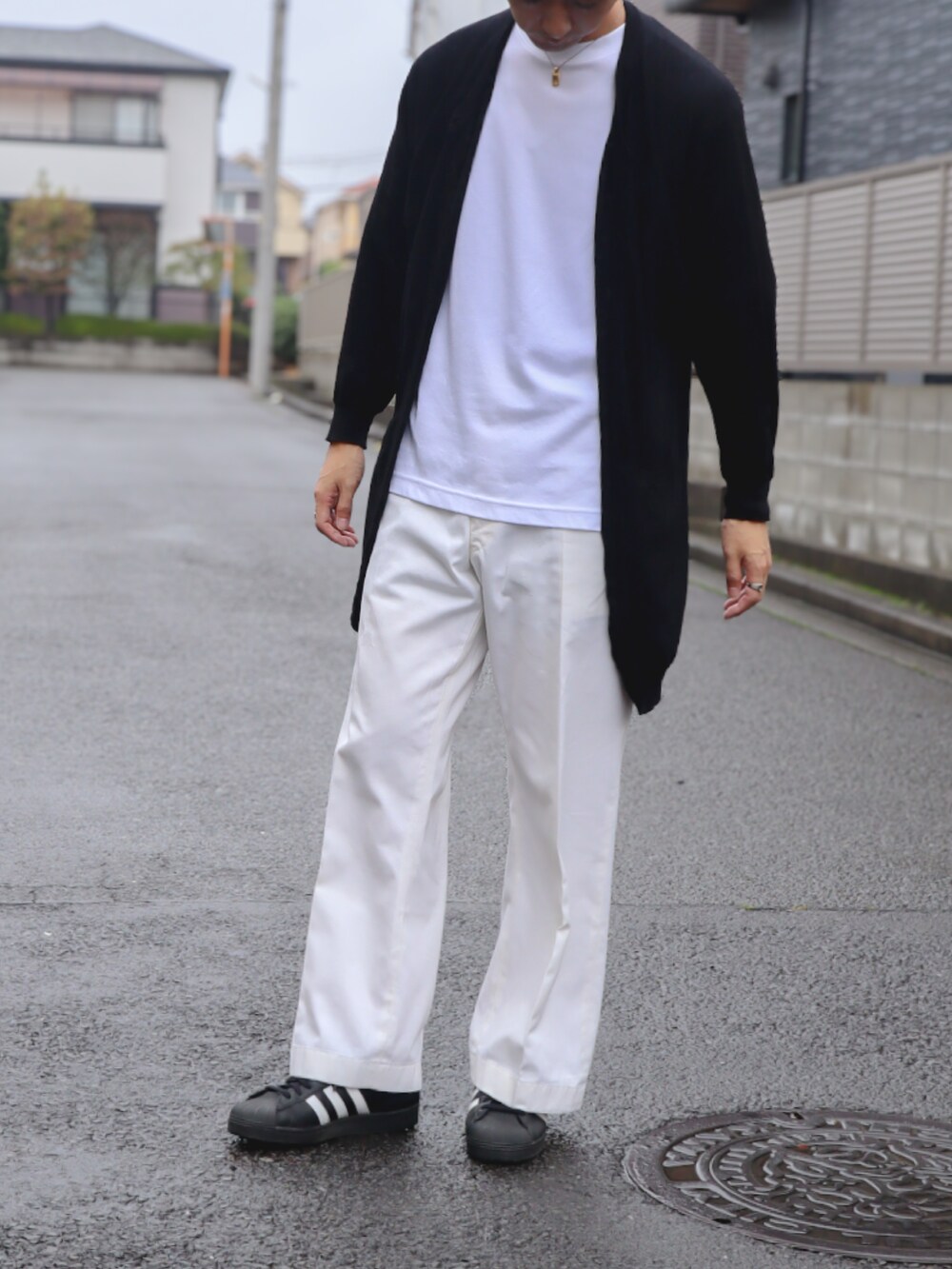 ホワイト系のチノパンツ、ブラック系のスニーカー、ブラック系のニット/セーターを着用したメンズの秋コーディネートの4枚目の写真