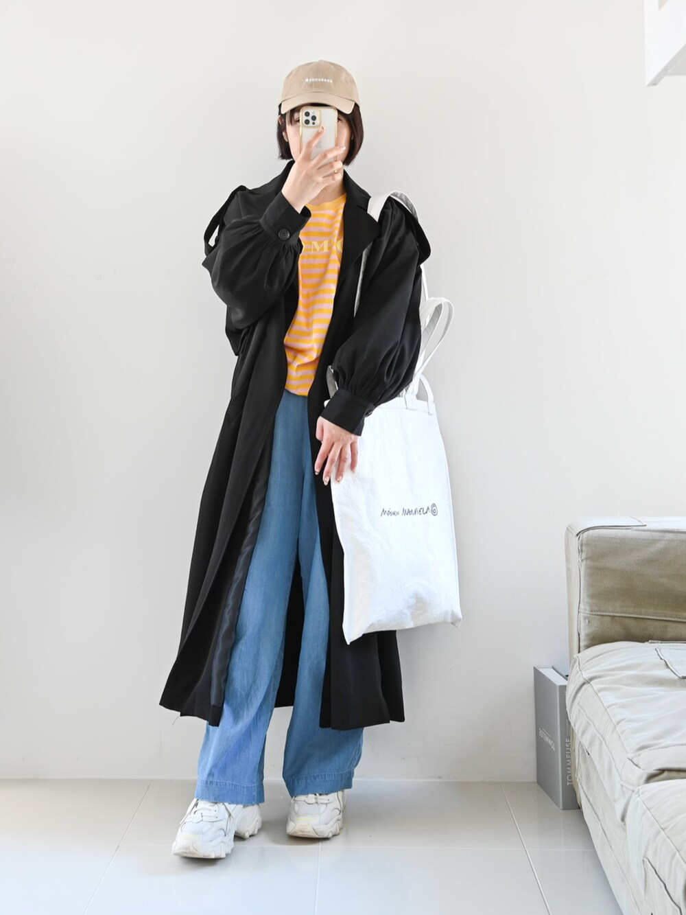 ブラック系のトレンチコート、ピンク系のTシャツ/カットソー、ホワイト系のトートバッグを着用したレディースの春コーディネートの2枚目の写真