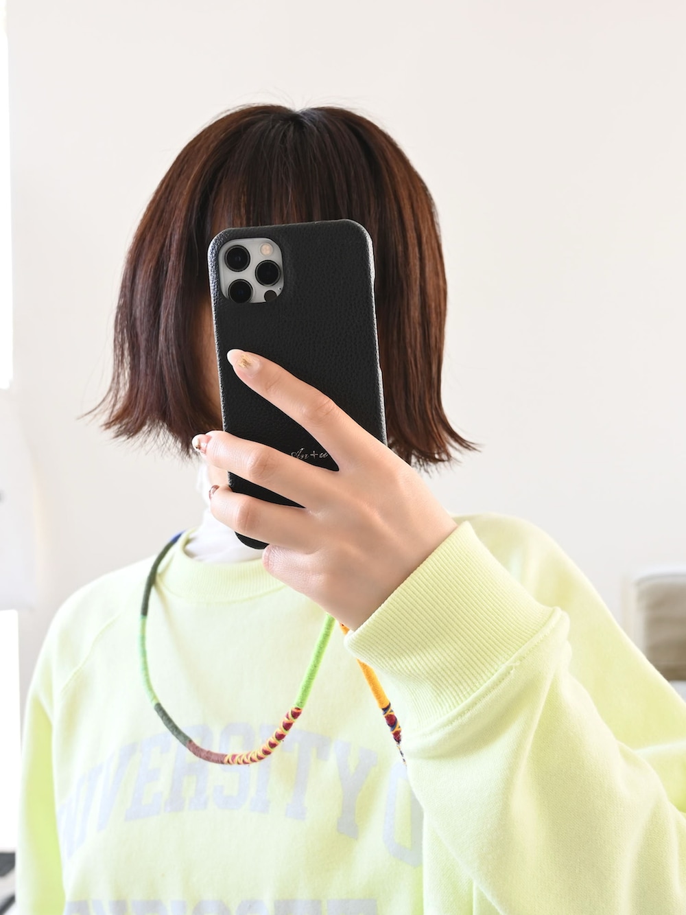 イエロー系のスウェット、ベージュ系のパンツ、グレー系のスニーカーを着用したレディースの春コーディネートの2枚目の写真