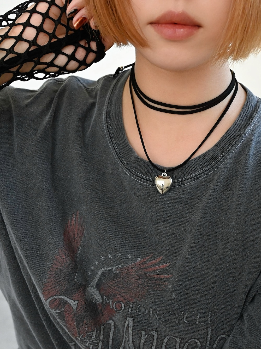 オレンジ系のスカート、ブラック系のTシャツ/カットソー、ベージュ系のスマホケース/カバーを着用したレディースの秋コーディネートの2枚目の写真