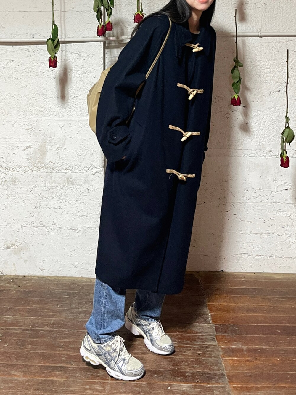 ベージュ系のショルダーバッグ、ブルー系のジャケット/アウター、ホワイト系のスニーカーを着用したレディースの冬コーディネートの2枚目の写真