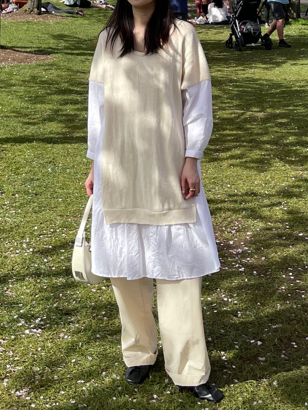 ホワイト系のワンピース、ホワイト系のハンドバッグ、ベージュ系のパンツを着用したレディースの春コーディネートの2枚目の写真