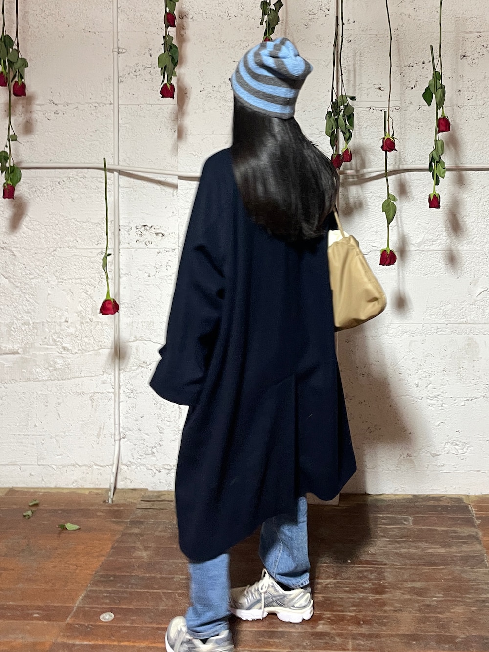 ベージュ系のショルダーバッグ、ブルー系のジャケット/アウター、ホワイト系のスニーカーを着用したレディースの冬コーディネートの3枚目の写真