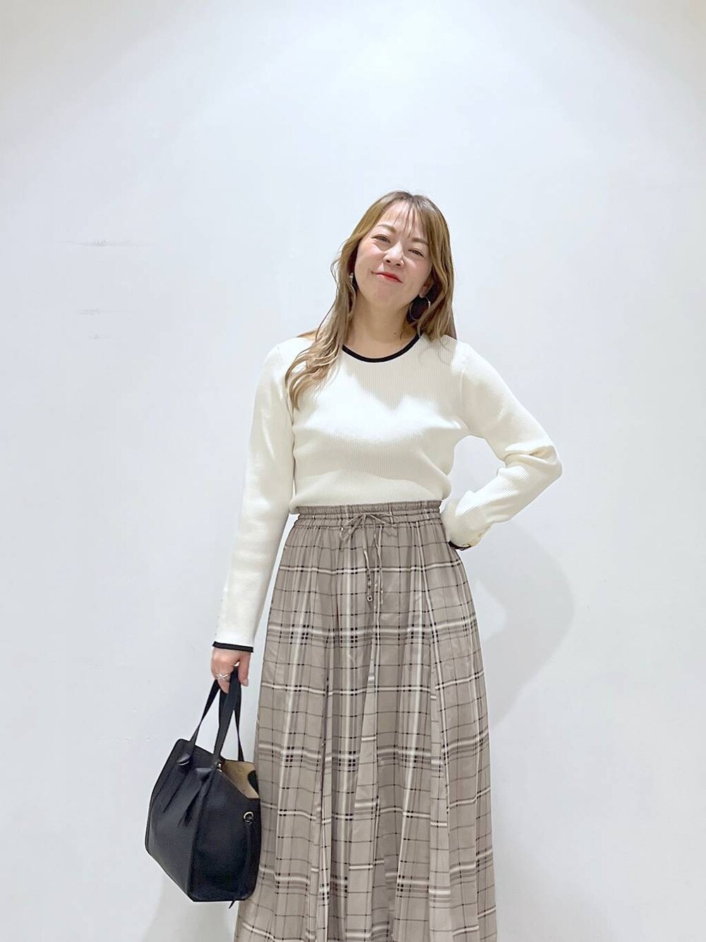 ホワイト系のTシャツ/カットソー、ホワイト系のパンプス、ブラック系のショルダーバッグを着用したレディースの春コーディネートの7枚目の写真