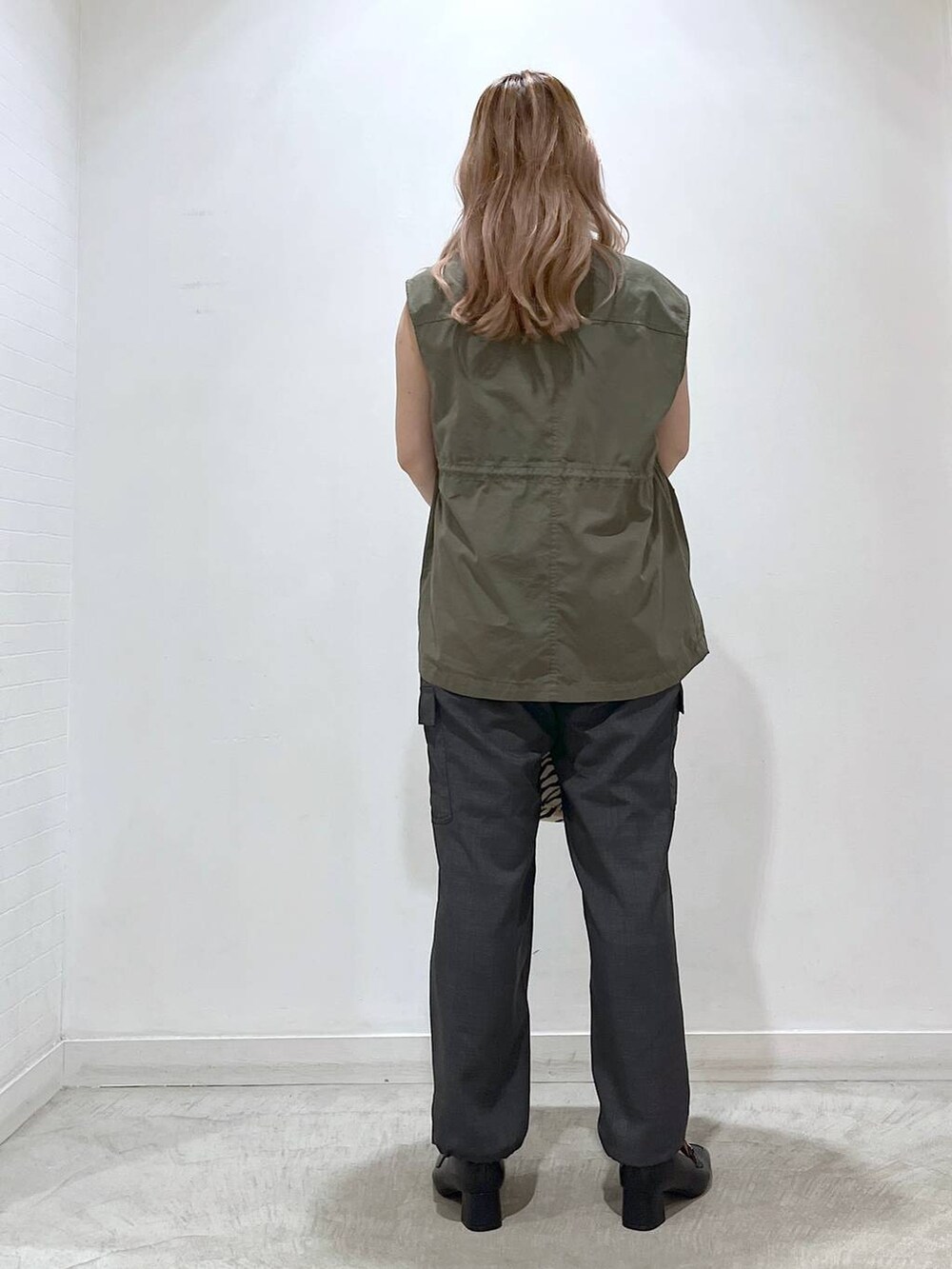 ホワイト系のタンクトップ、ブラック系のローファー、グレー系のカーゴパンツを着用したレディースの夏コーディネートの2枚目の写真