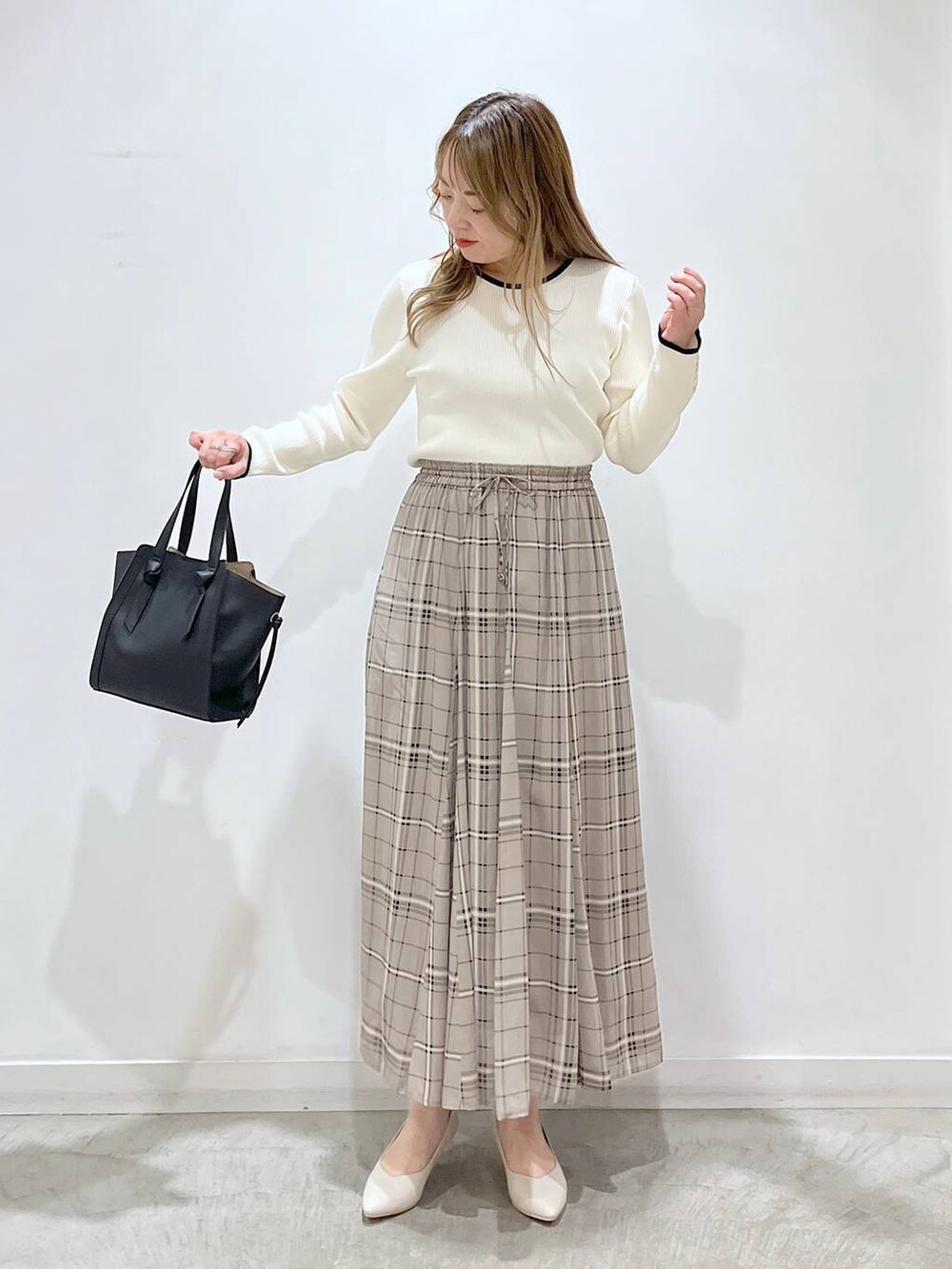 ホワイト系のTシャツ/カットソー、ホワイト系のパンプス、ブラック系のショルダーバッグを着用したレディースの春コーディネートの6枚目の写真